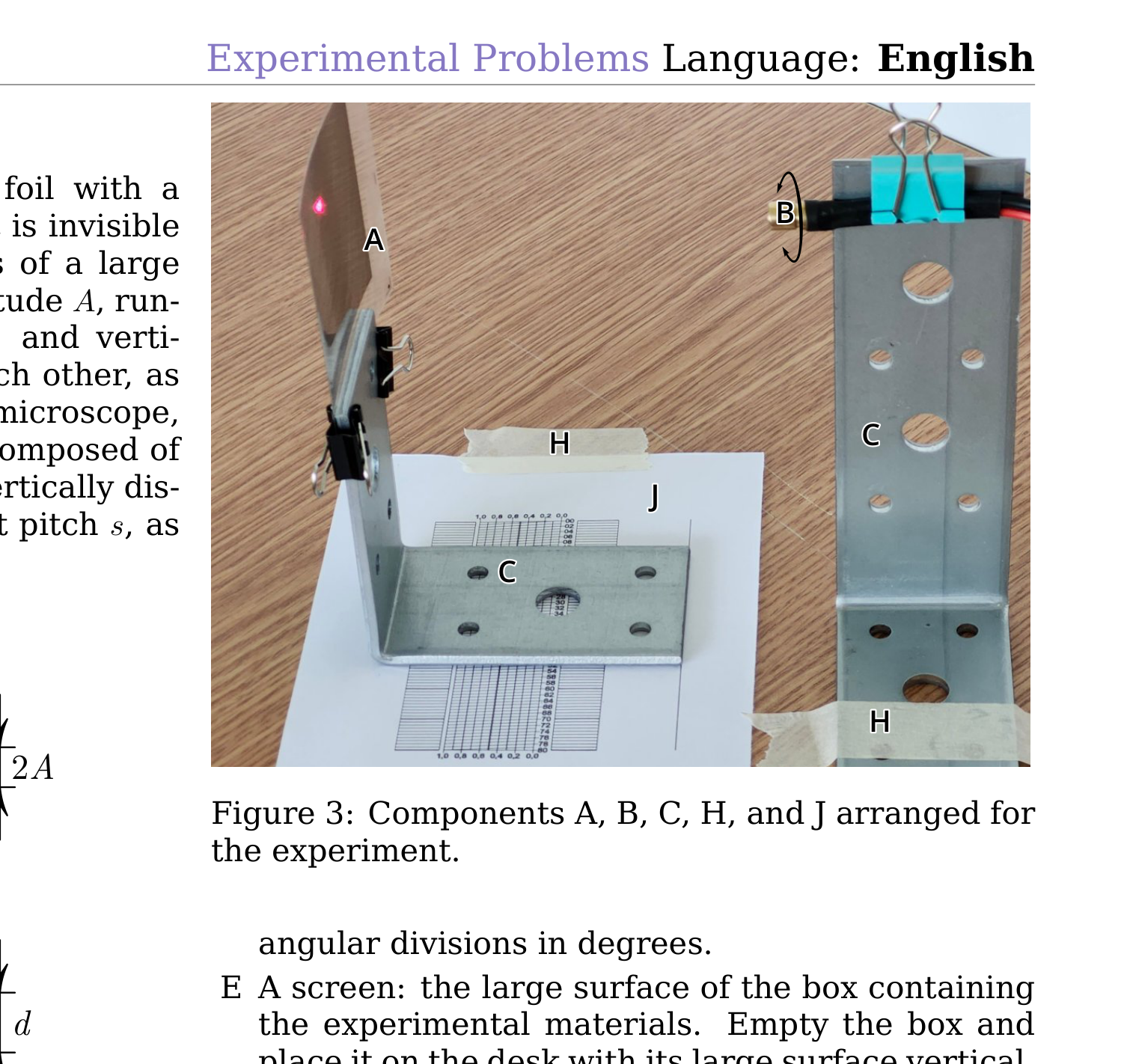 Photo of the setup: foil A on an L-shaped plank, laser diode B mounted on another plank, printed goniometer J and steel plank C on the desk, adhesive tape H.
